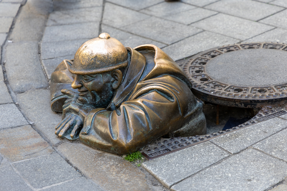 Bratislava, la statua di Čumil che sbuca dal tombino
